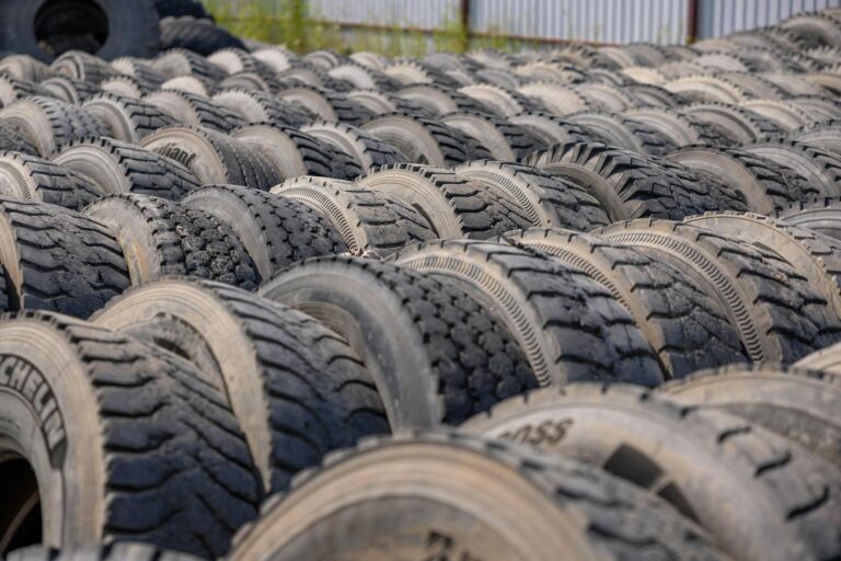 A large outdoor storage yard filled with rows of old tires, ideal for concepts like recycling or industrial use.
