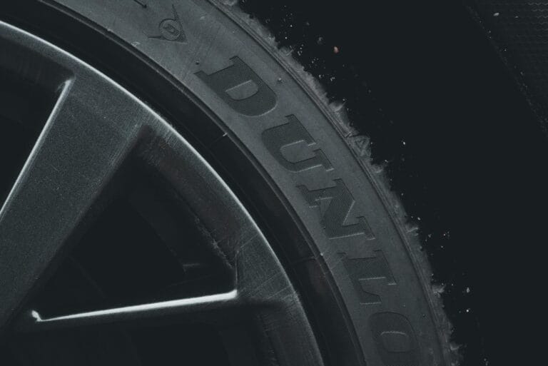 Detailed close-up of a Dunlop tire and rim showcasing its texture and brand text.